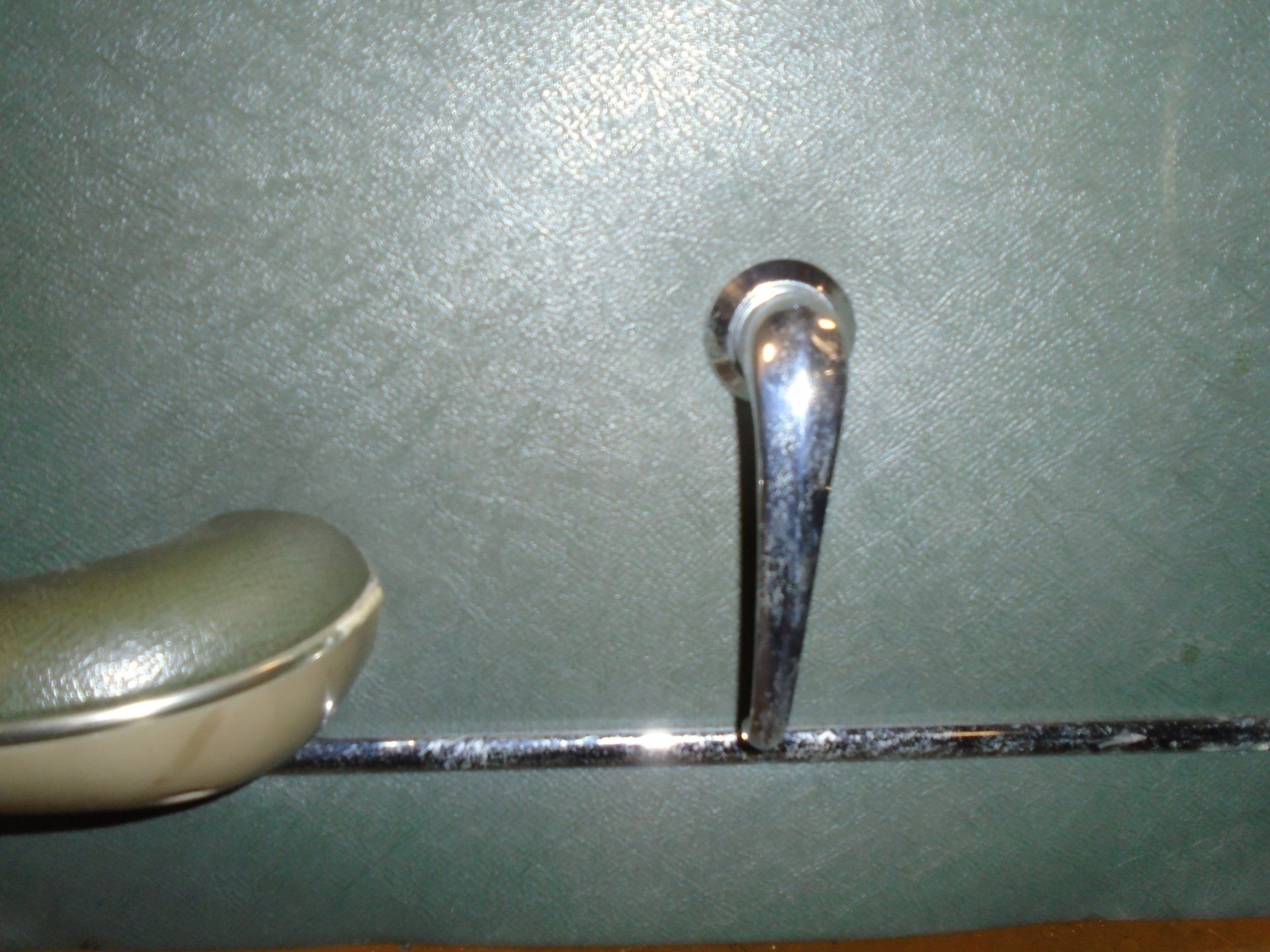 Green car door handle with chrome accents.