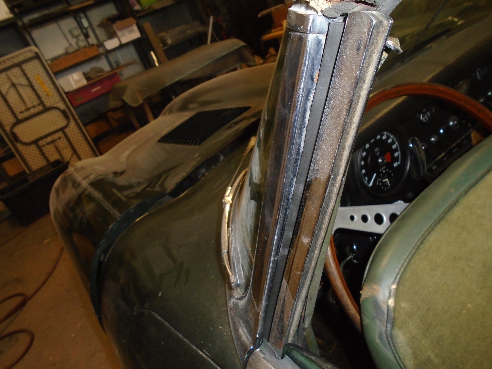 Green classic car interior with welded metal door frame and dashboard.