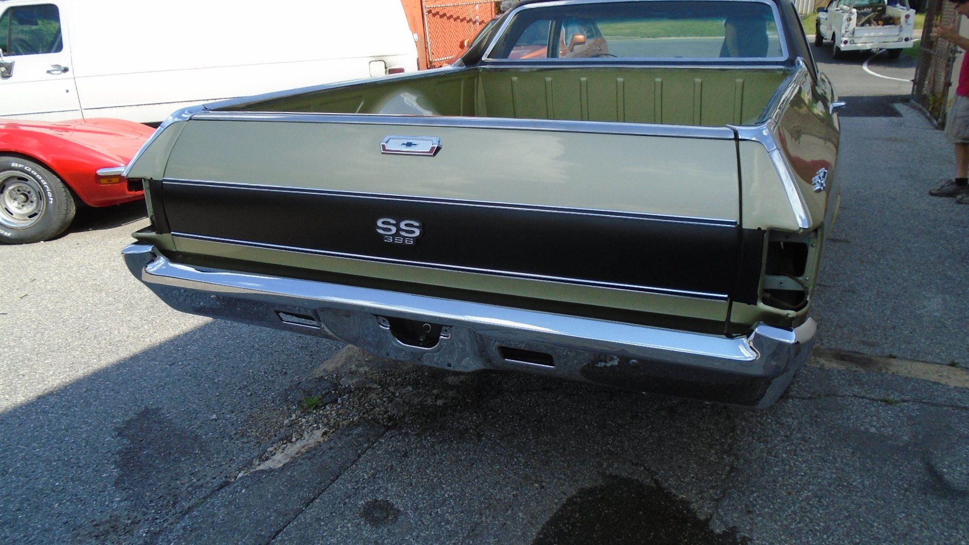 Green and black Chevrolet El Camino SS parked on asphalt, rear view, chrome bumper.