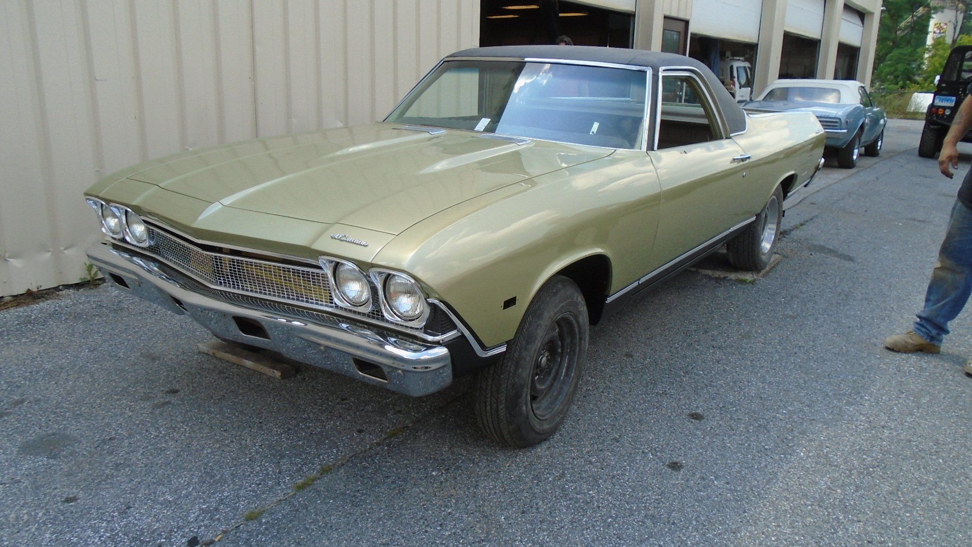 Gold Chevrolet El Camino parked outside a building.