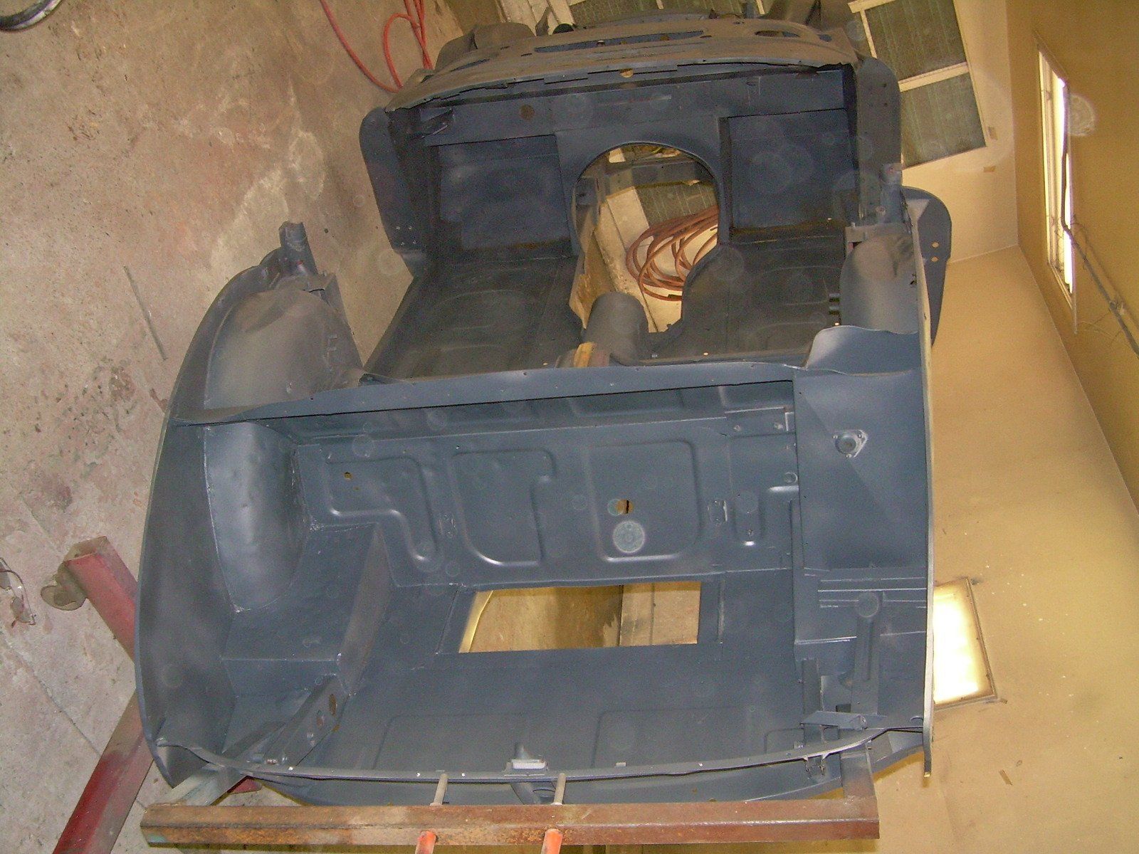 Gray interior of a vintage car chassis, possibly undergoing restoration.