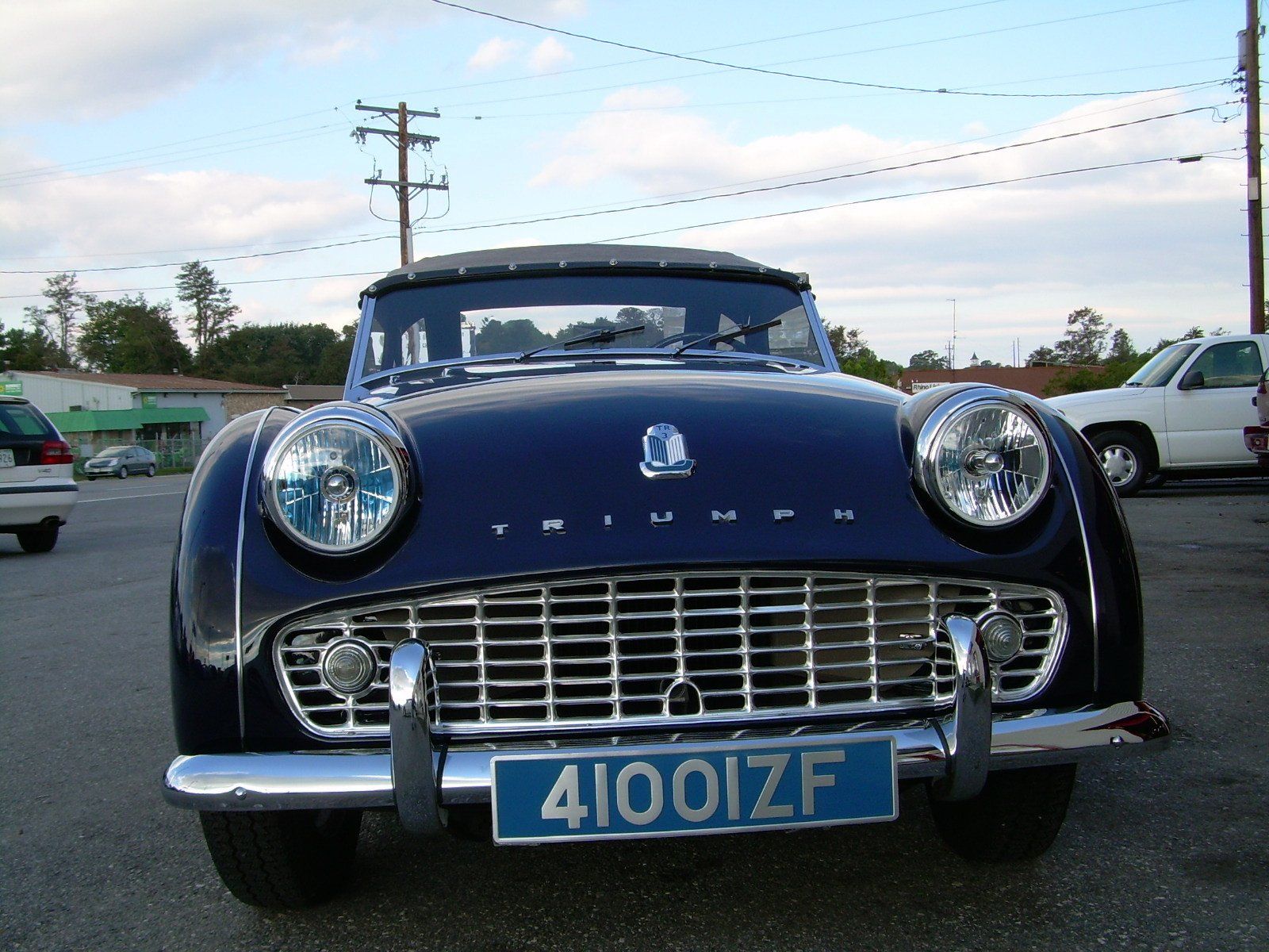 Dark blue vintage Triumph sports car with chrome accents and license plate 