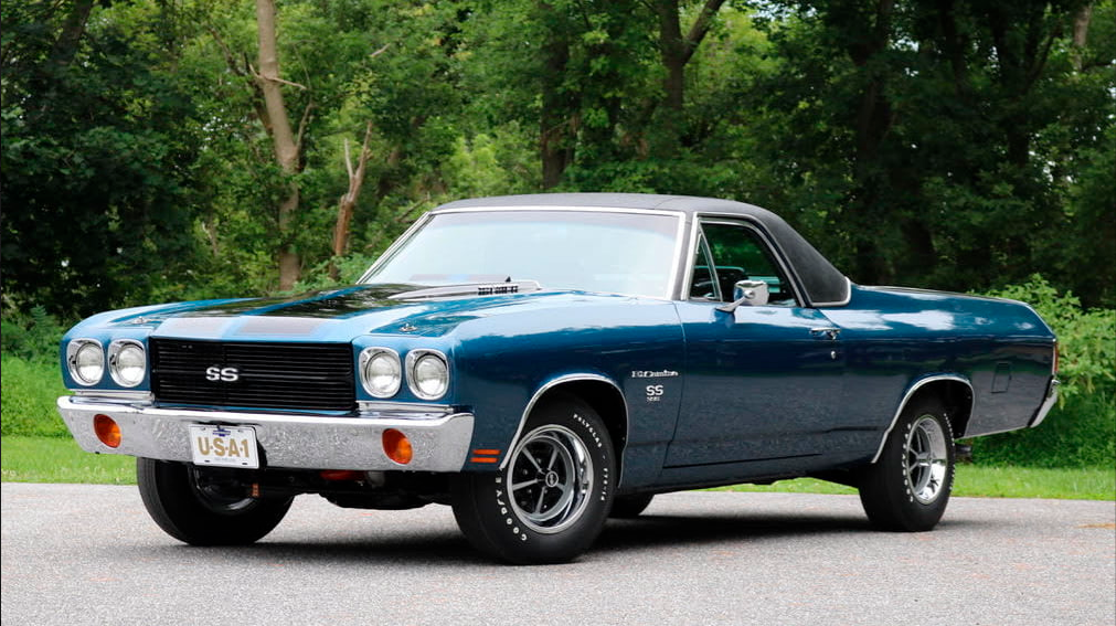 Blue and black 1970 Chevrolet El Camino SS parked on a paved area with a background of trees.