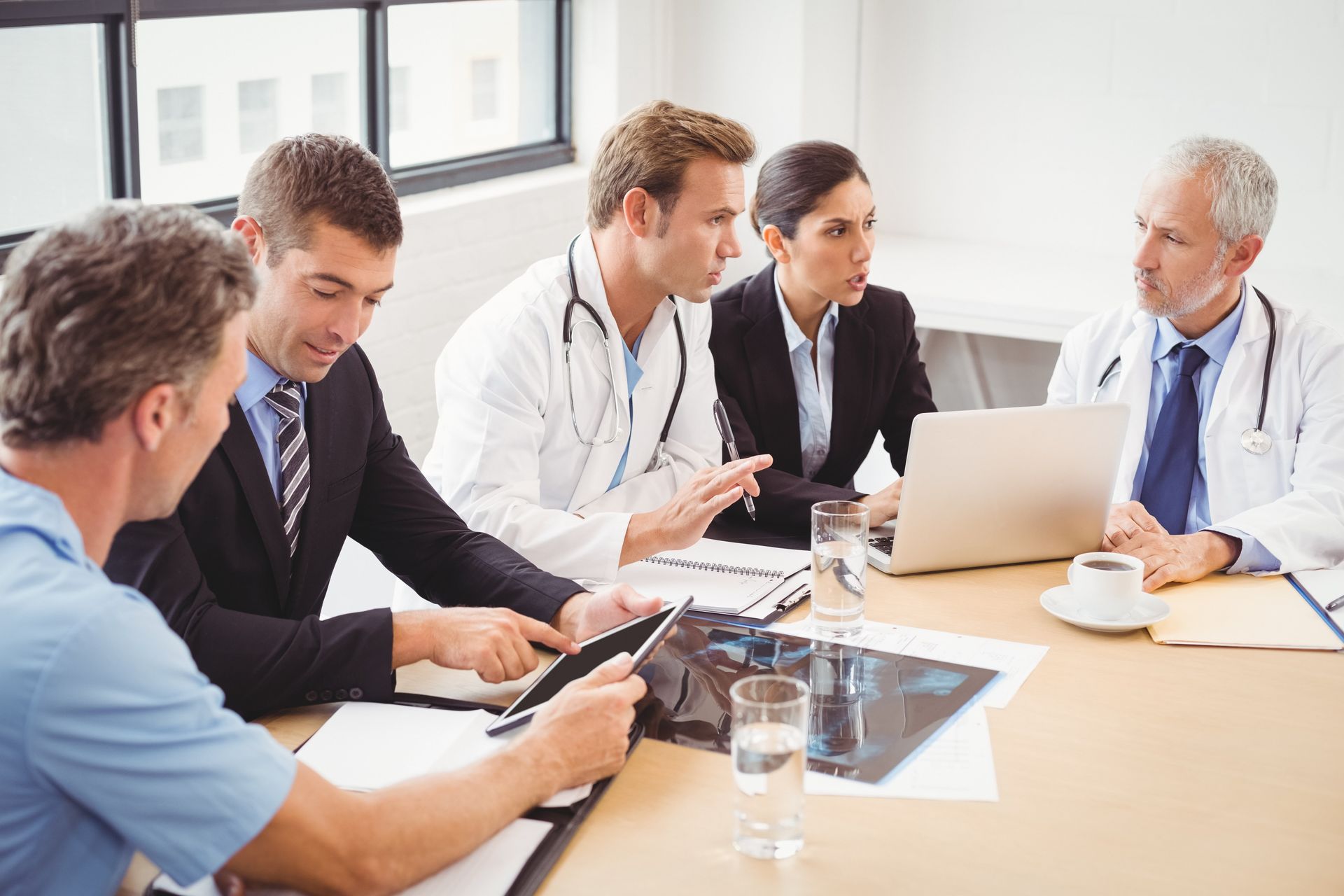 Doctors Meeting A group of doctors and business people are having a meeting at a table.