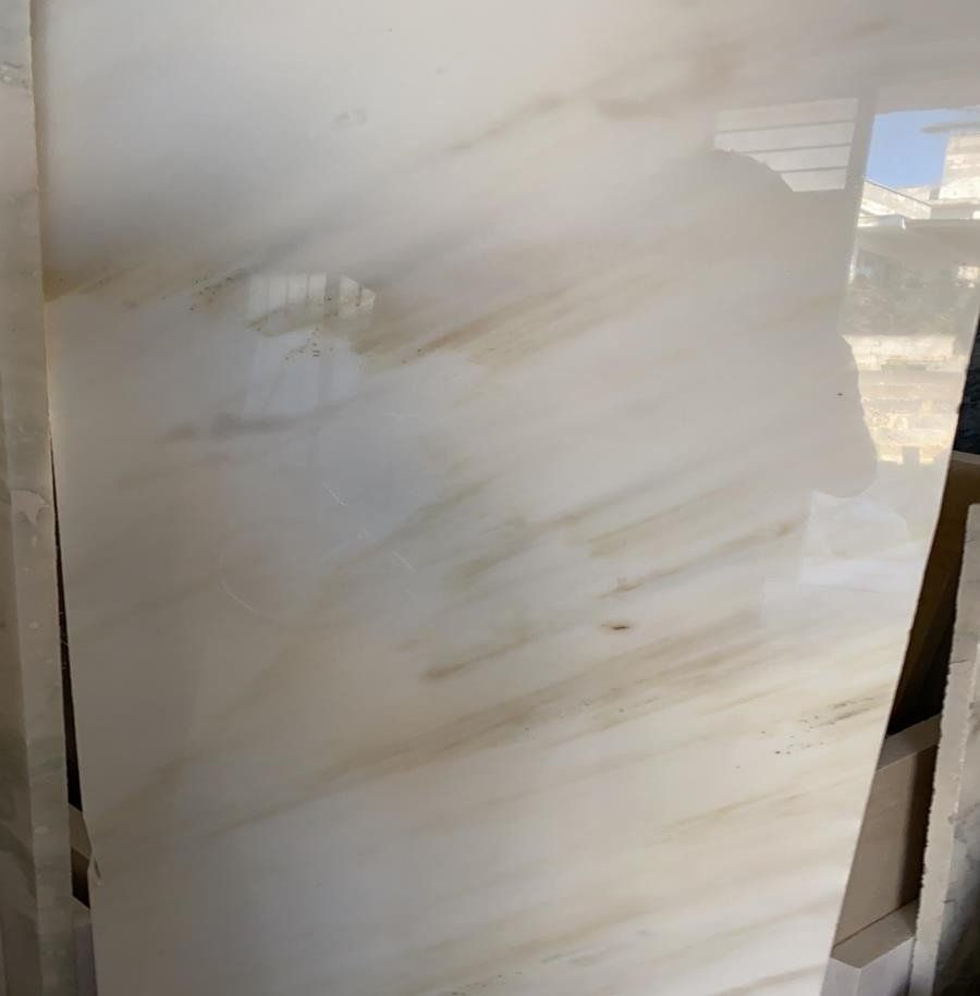 Una grande lastra di marmo bianco levigato con venature diagonali di un delicato color marrone.