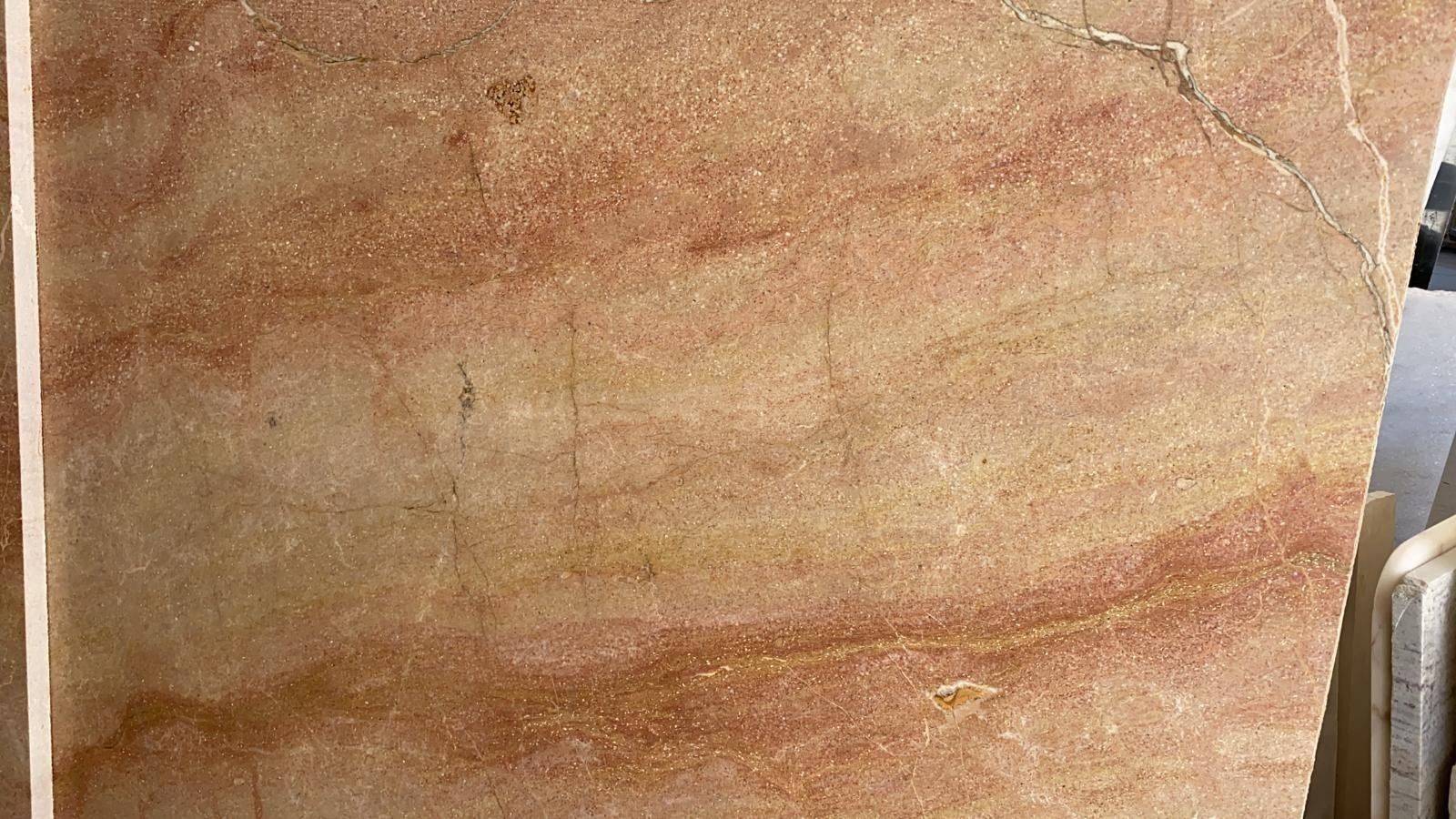 Una lastra rettangolare di arenaria levigata caratterizzata da strati orizzontali di venature minerali color cuoio, beige e marrone rossastro.