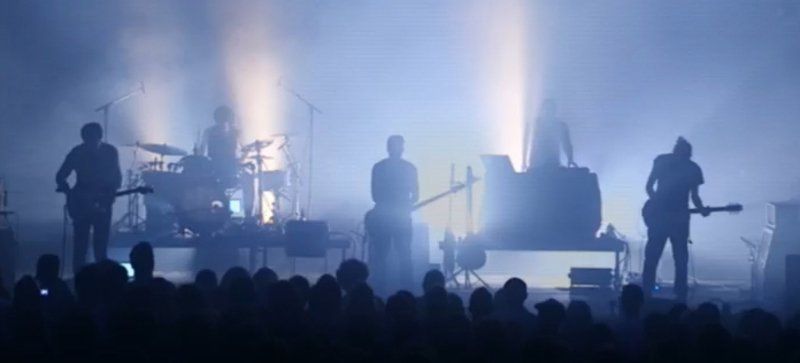a group of people are playing instruments on a stage in front of a crowd .