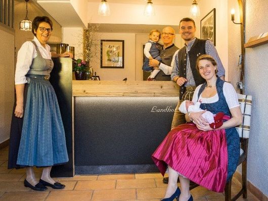 Eine Gruppe von Menschen posiert vor einer Theke für ein Foto.