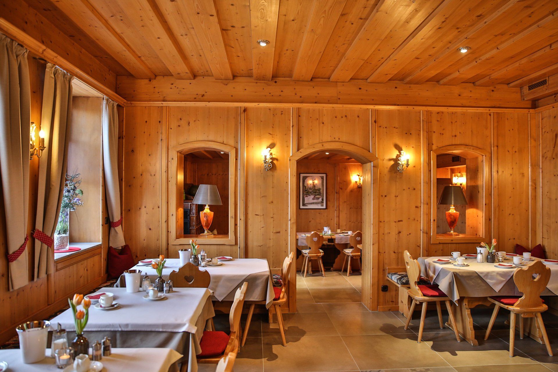 Un ristorante con tavoli e sedie in legno e soffitto in legno