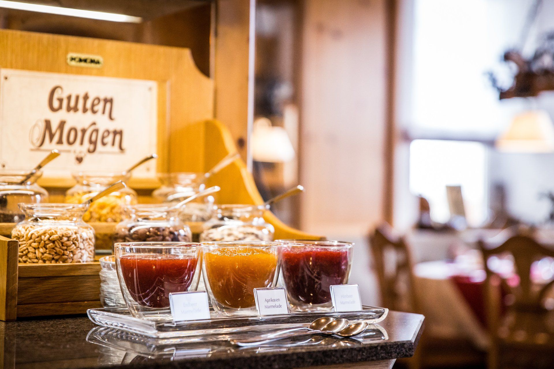 Un tavolo da buffet con sopra barattoli di marmellata e granola.