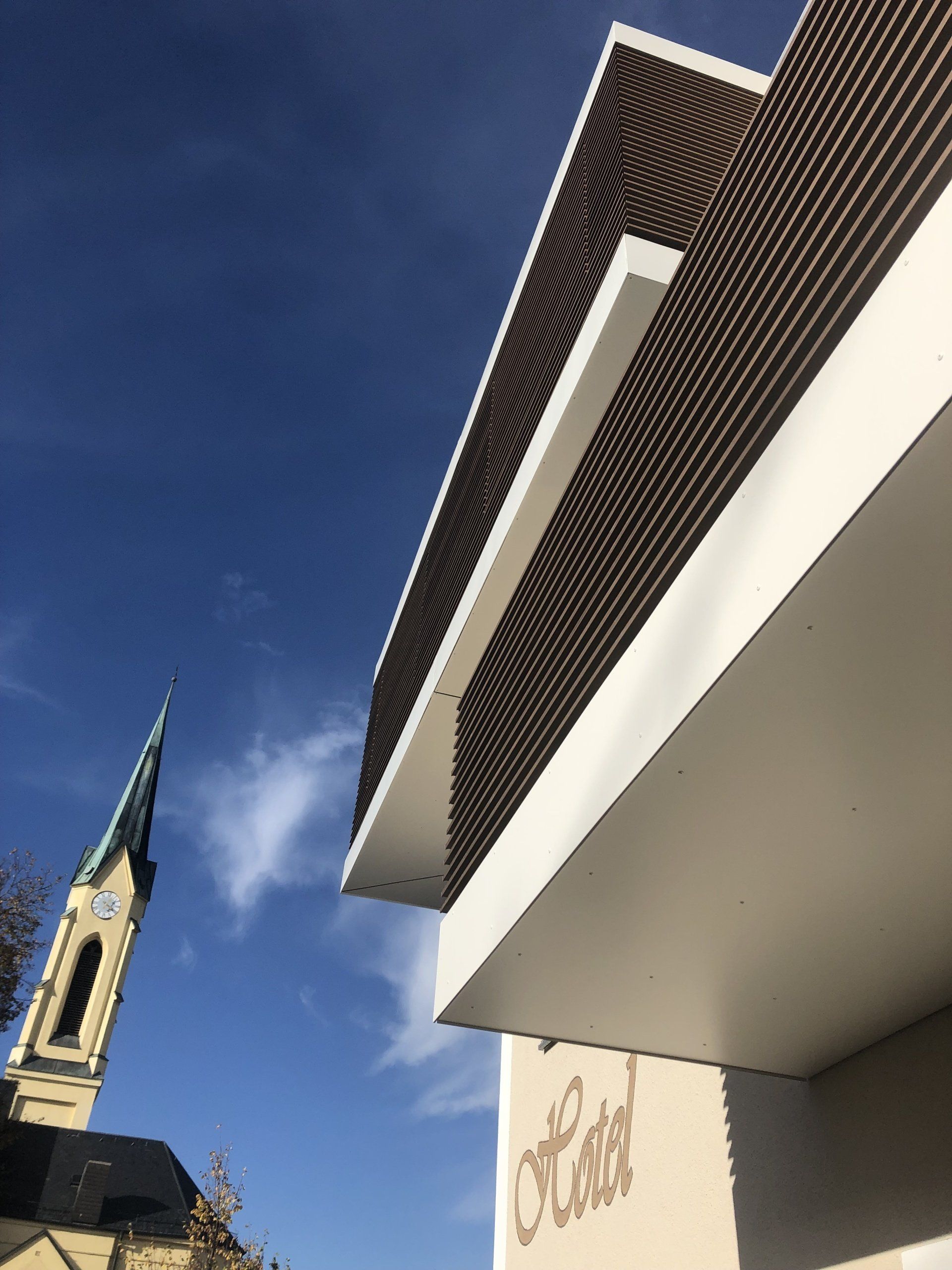 Un edificio con un balcone e una chiesa sullo sfondo.