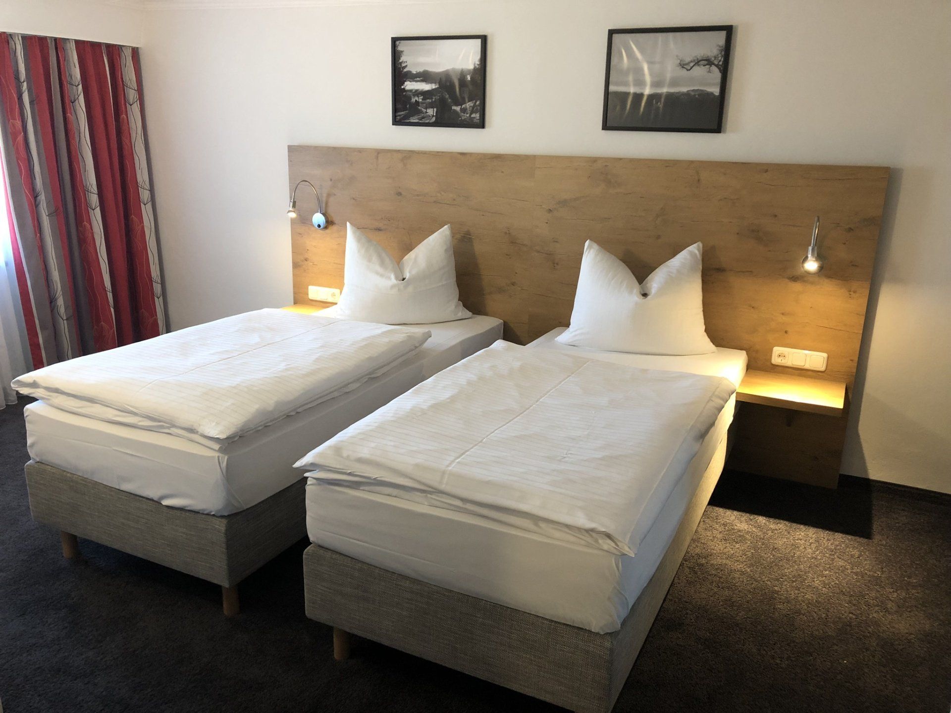 Una camera d'albergo con due letti e una testiera in legno