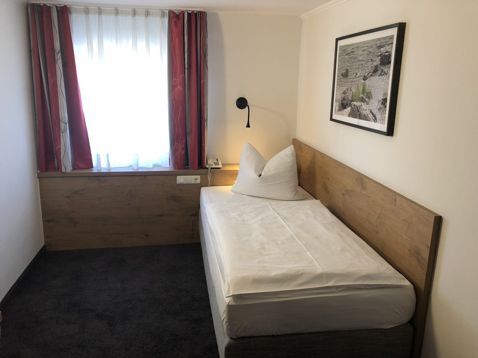 Ein Schlafzimmer mit einem Einzelbett und einem Bild an der Wand