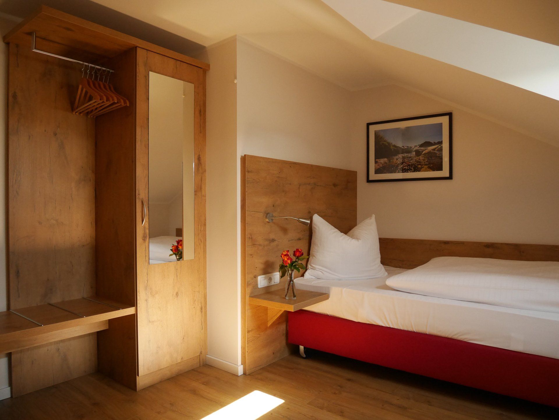 Una camera da letto con un letto singolo e un quadro alla parete.