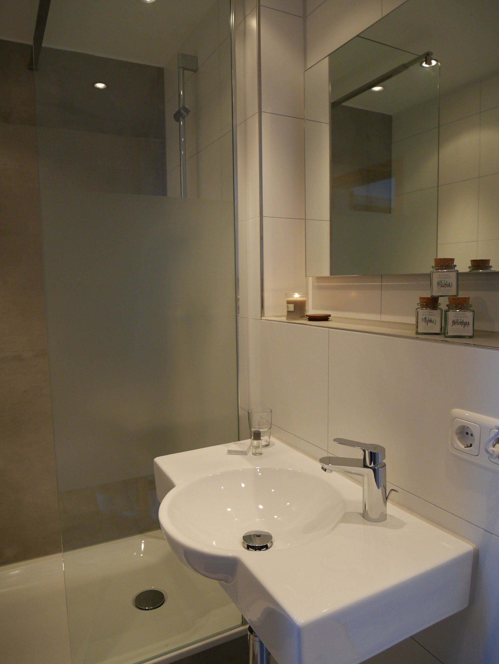 Un bagno con un lavandino, una doccia e uno specchio