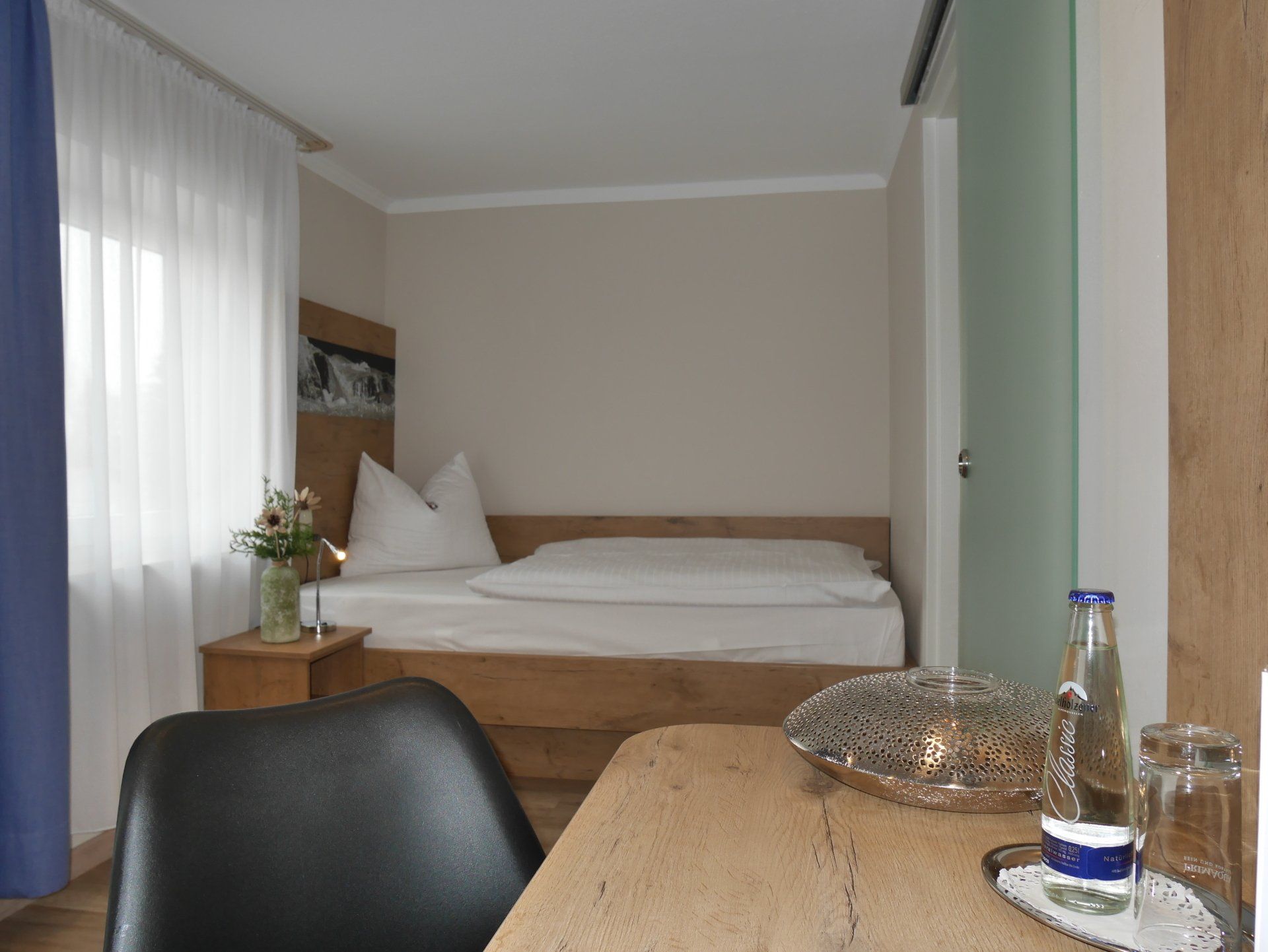 Una camera da letto con un letto e una scrivania con sopra una bottiglia d'acqua.