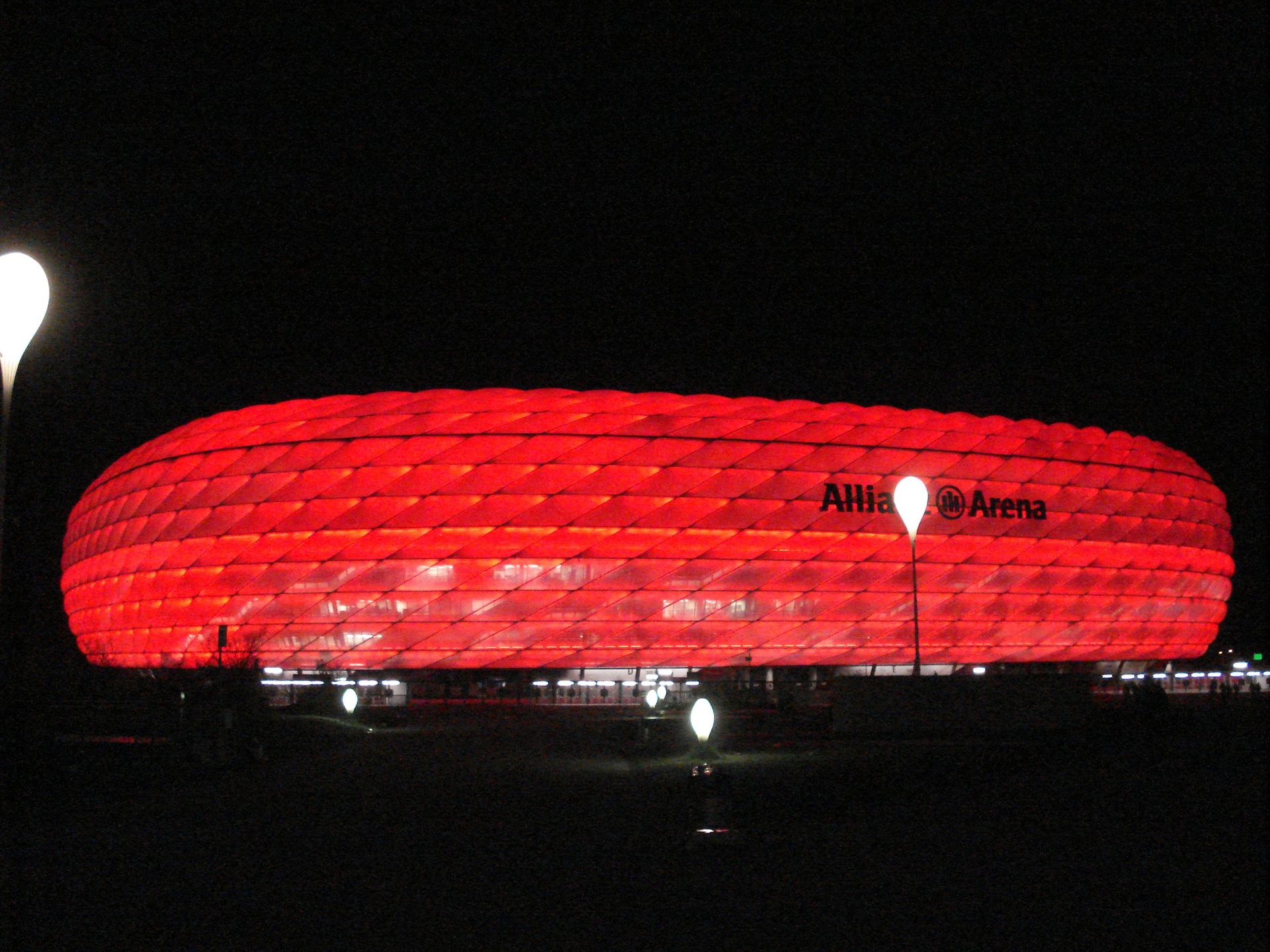 The allianz arena is lit up red at night