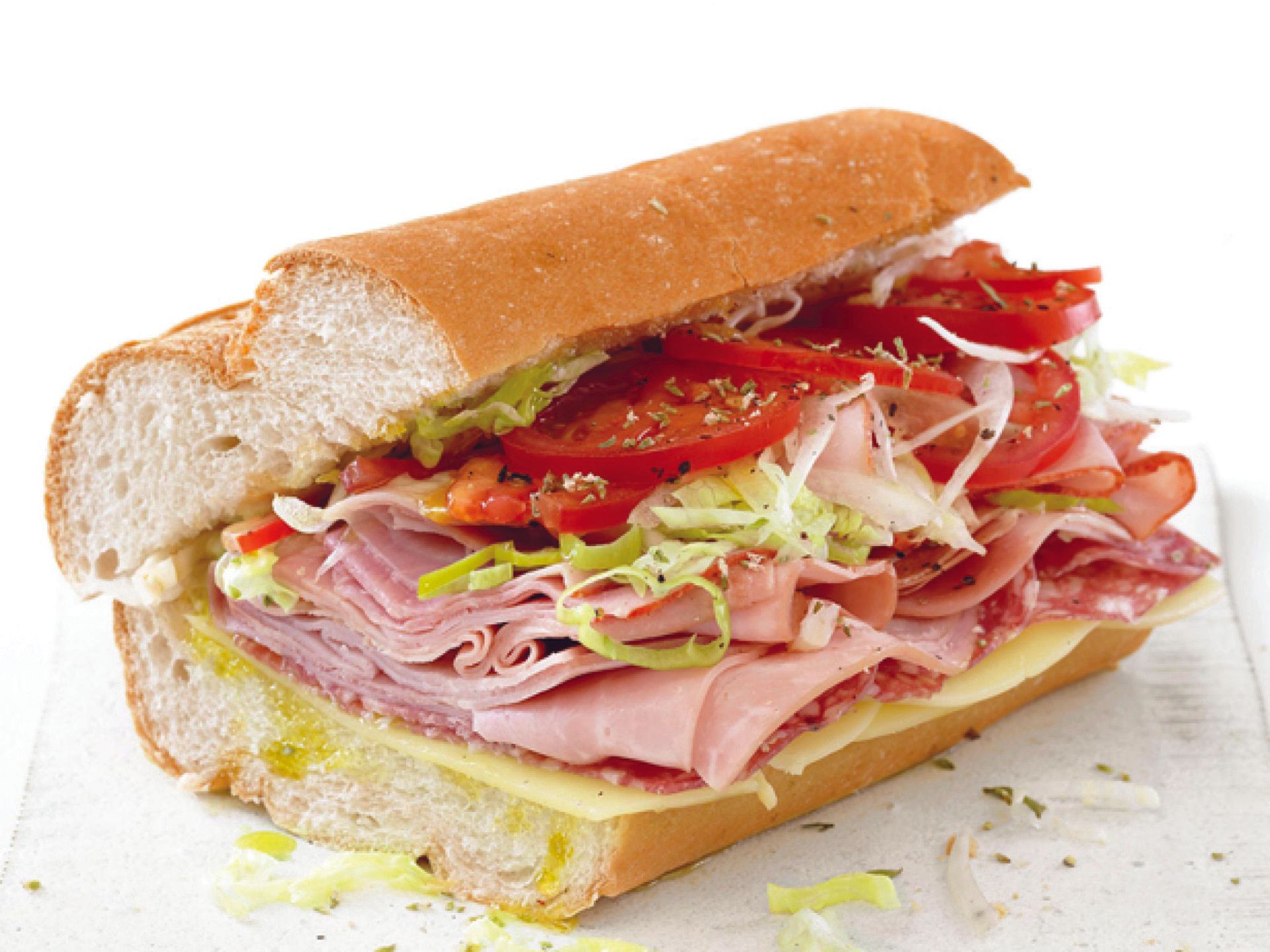 A sub sandwich with ham cheese lettuce and tomatoes
