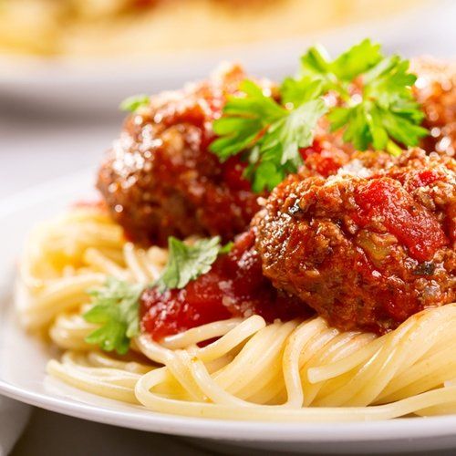 A close up of a plate of spaghetti and meatballs