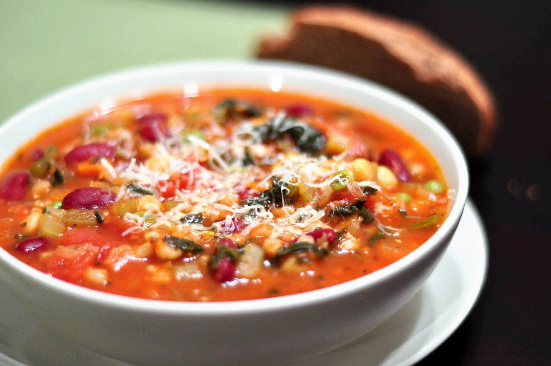 A bowl of soup with beans and cheese on top