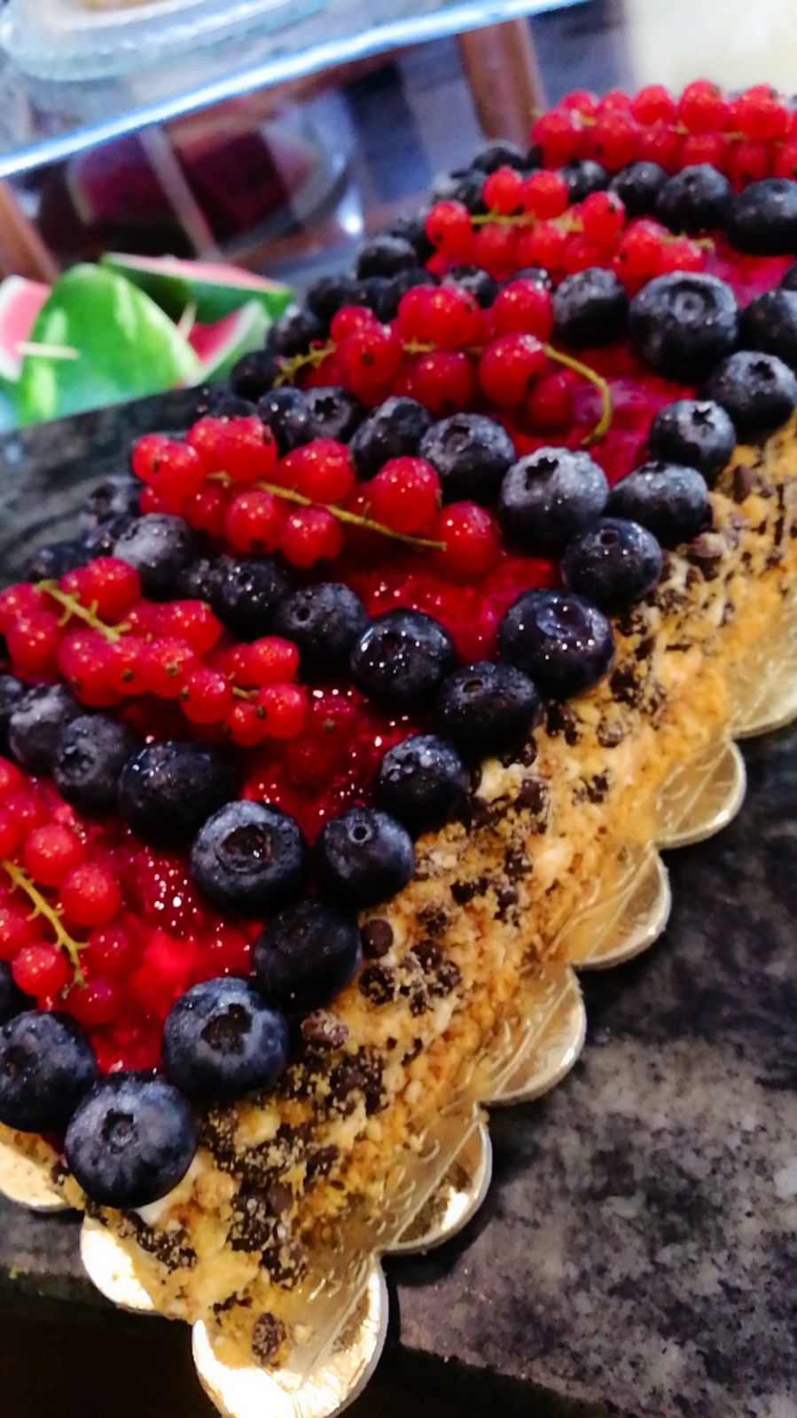 Torta guarnita con ribes rossi e mirtilli.