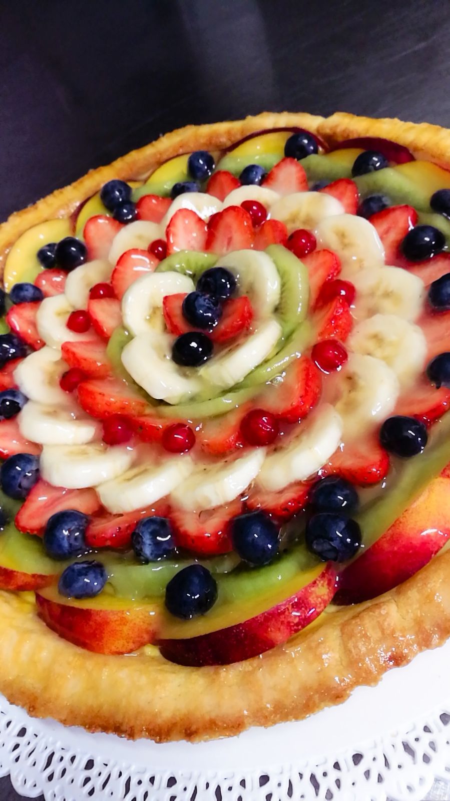 Crostata di frutta con fragole, banane, kiwi, mirtilli e ribes rossi.