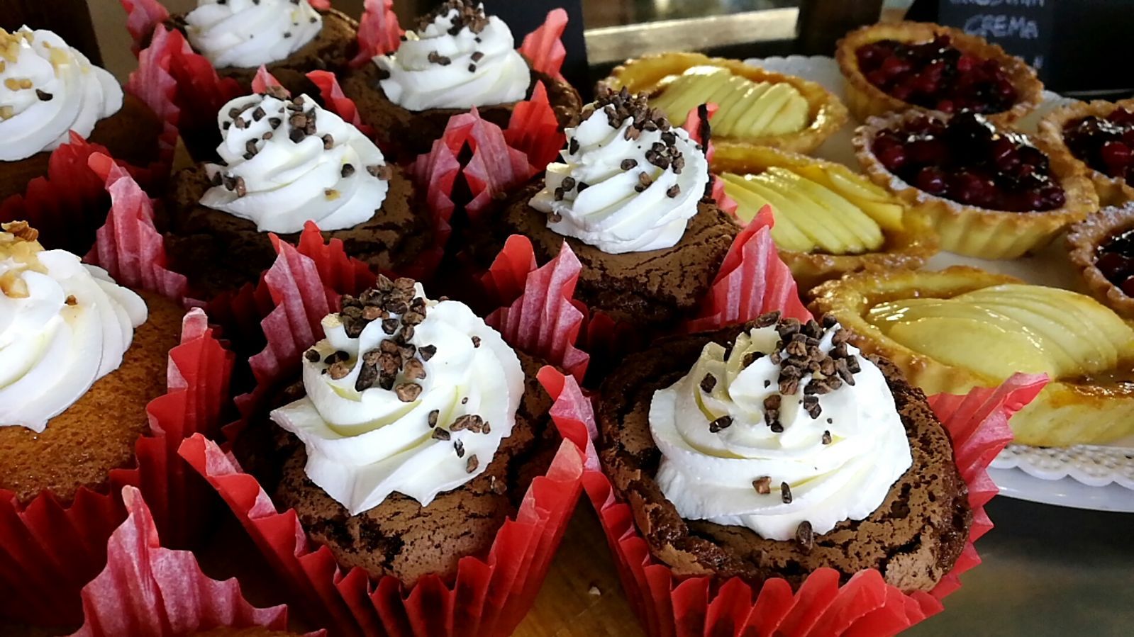 Cupcake brownie con panna montata e scaglie di cioccolato; crostate con frutta.