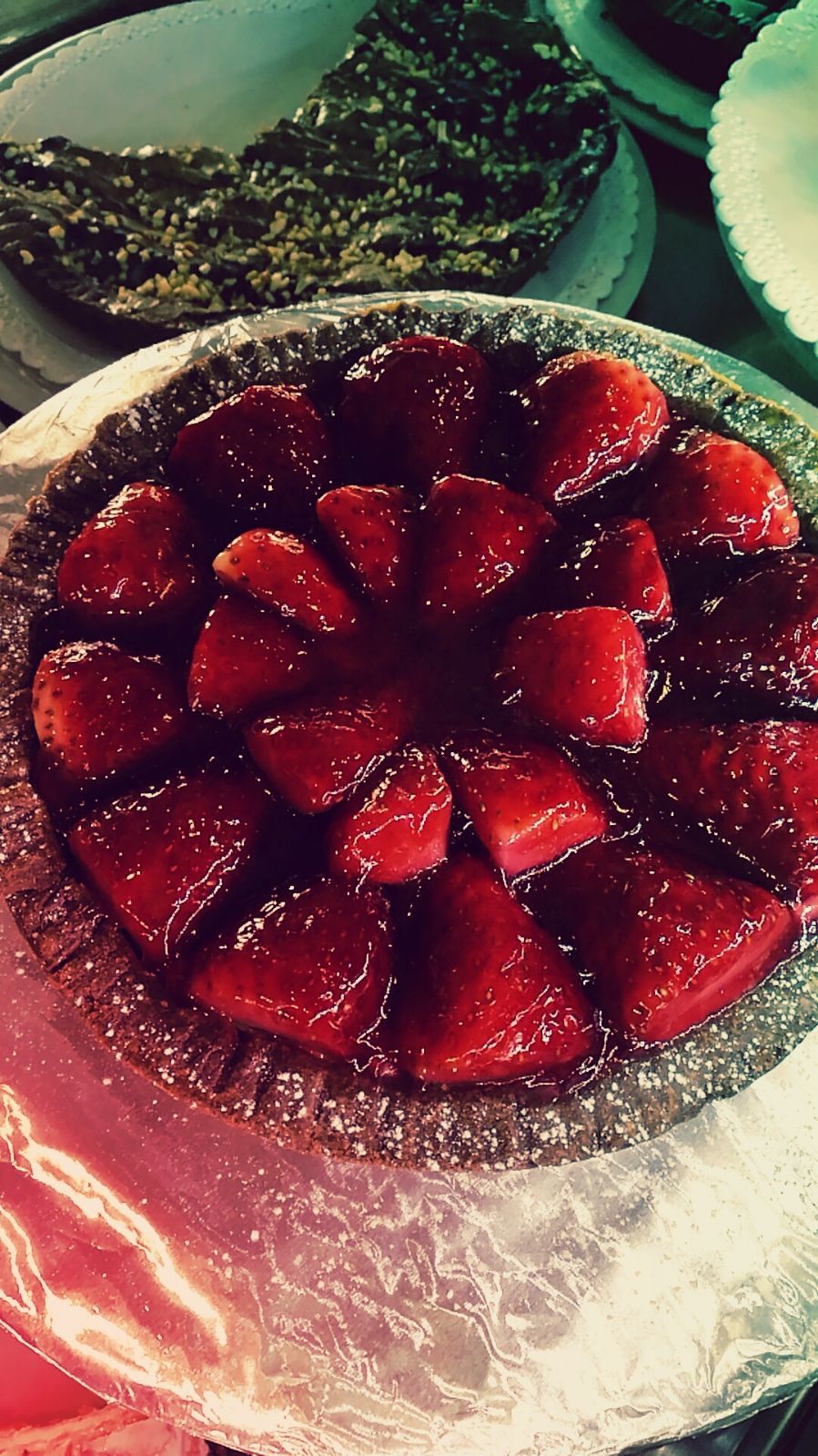 Crostata di fragole, fragole glassate disposte in modo circolare su una base di crosta di torta argentata.