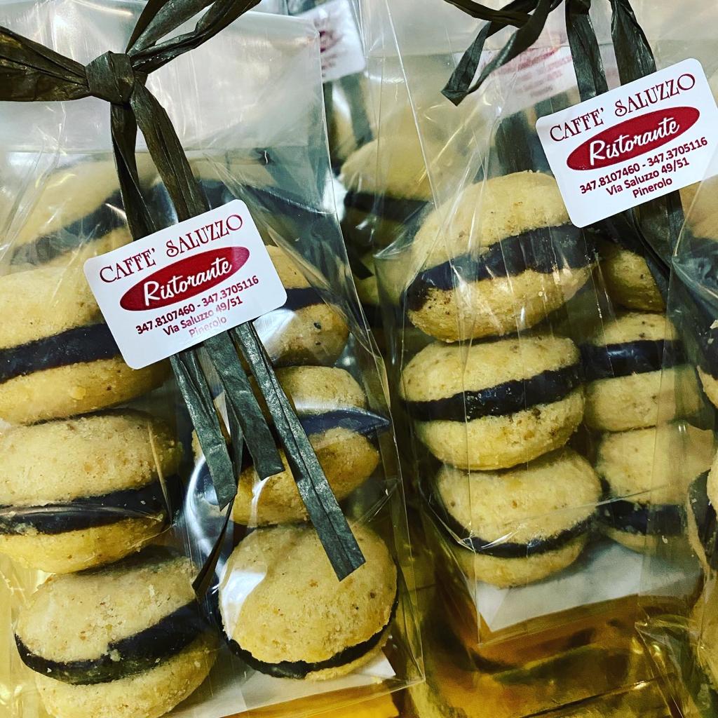 Sacchetti di biscotti sandwich con ripieno scuro, legati con un nastro e recanti l'etichetta