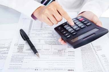 Man calculating numbers for his taxes - Long Forms Short Forms in Syracuse NY Man calculating numbers for his taxes - Long Forms Short Forms in Syracuse NY