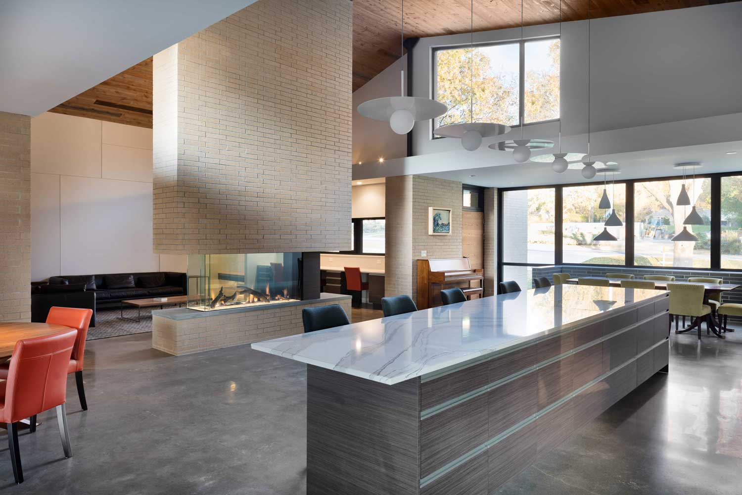Modern kitchen with large island and open view to the living room and fireplace