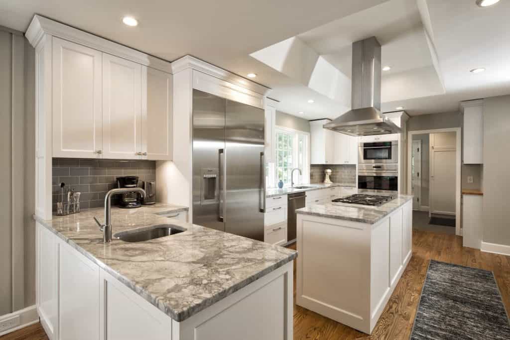 Custom kitchen with white cabinetry and luxury stone countertops