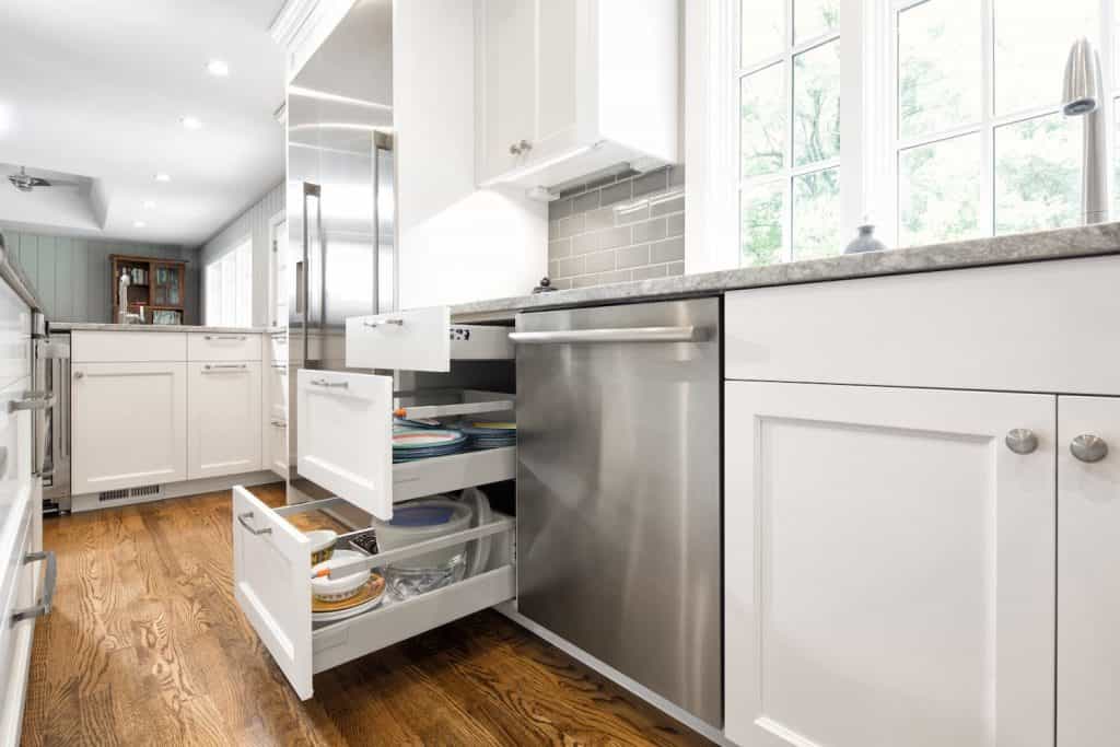 Custom kitchen cabinets shown open with three layers of drawers
