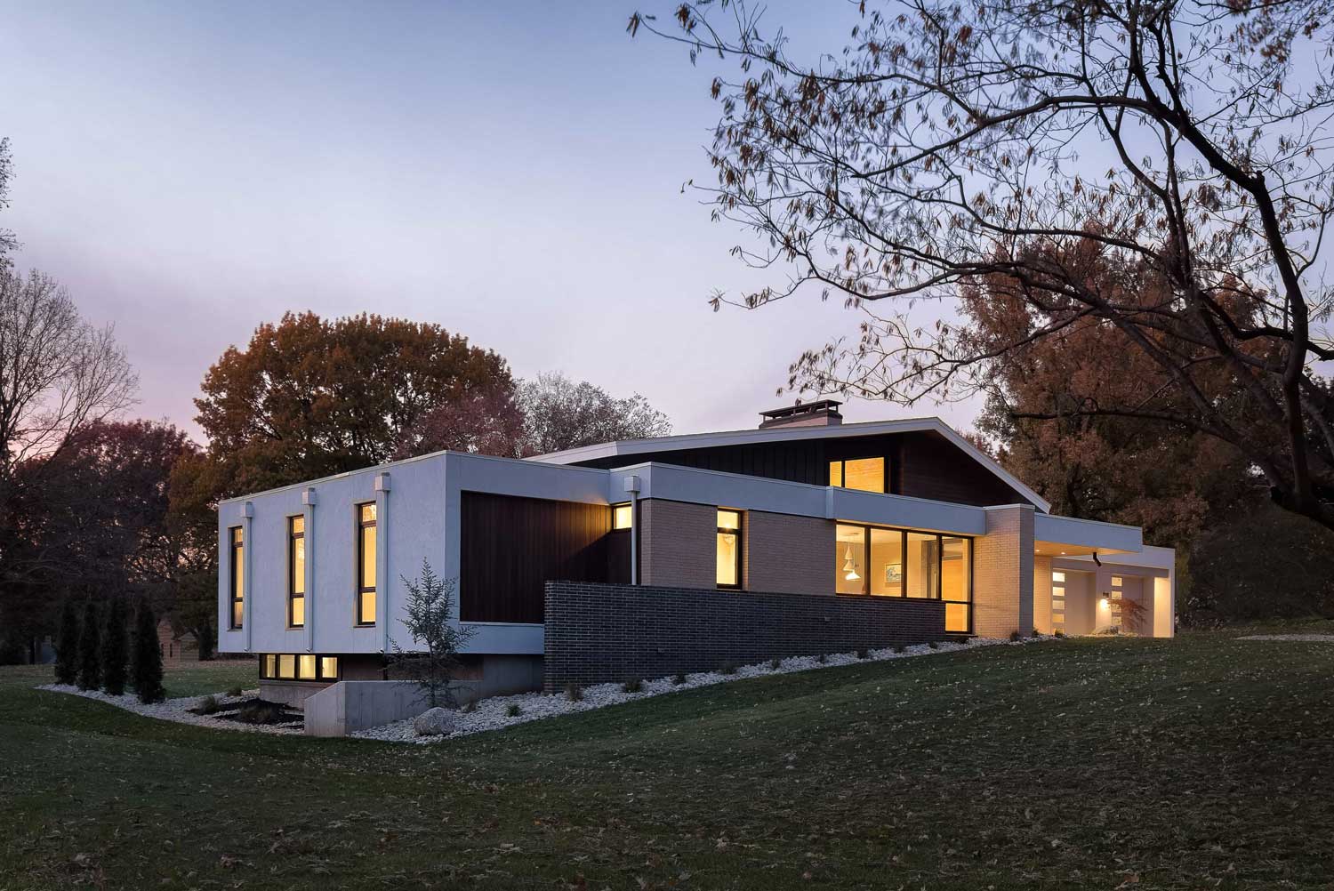 Exterior view of modern mid-century style home at dusk