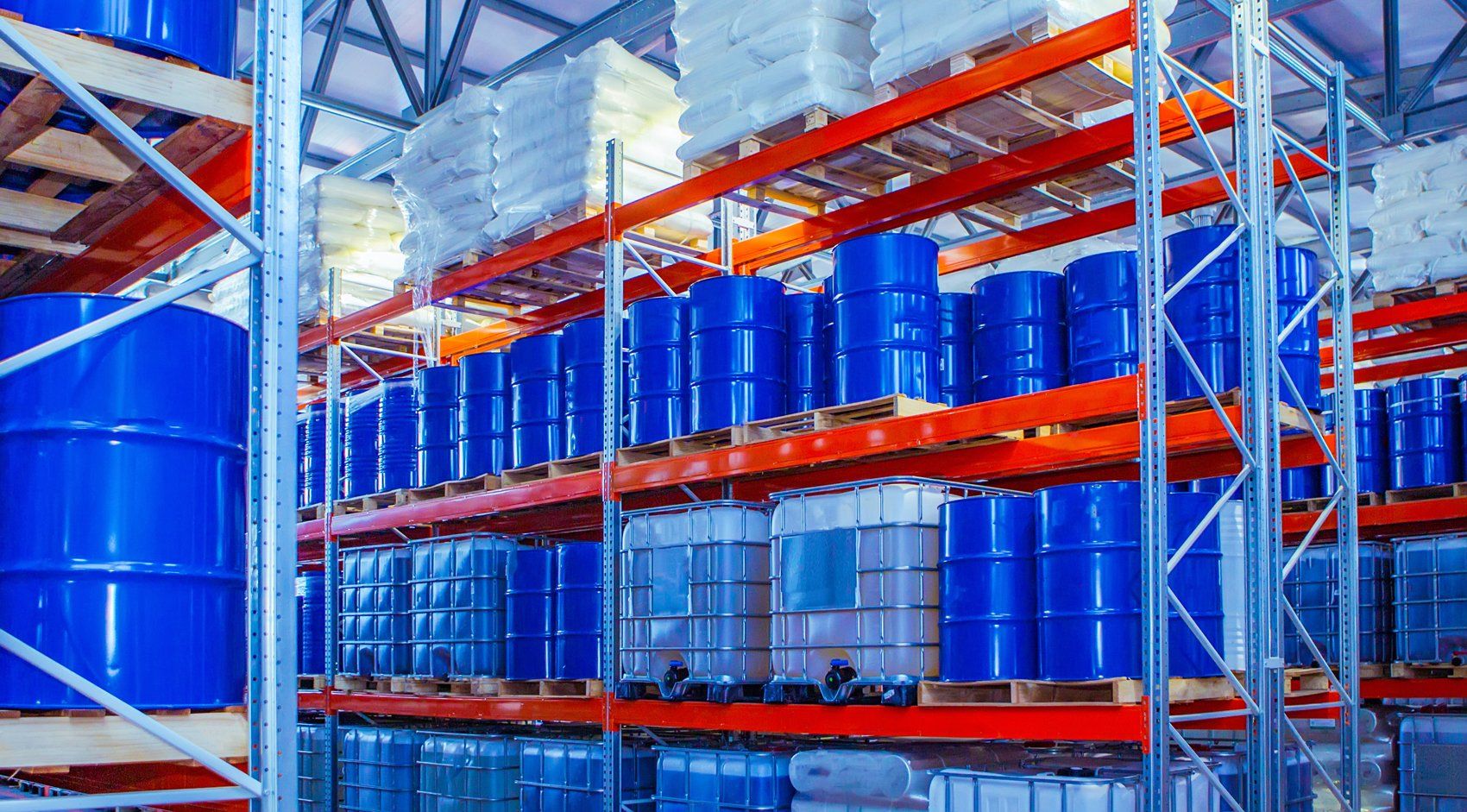 A warehouse filled with lots of blue barrels on shelves.