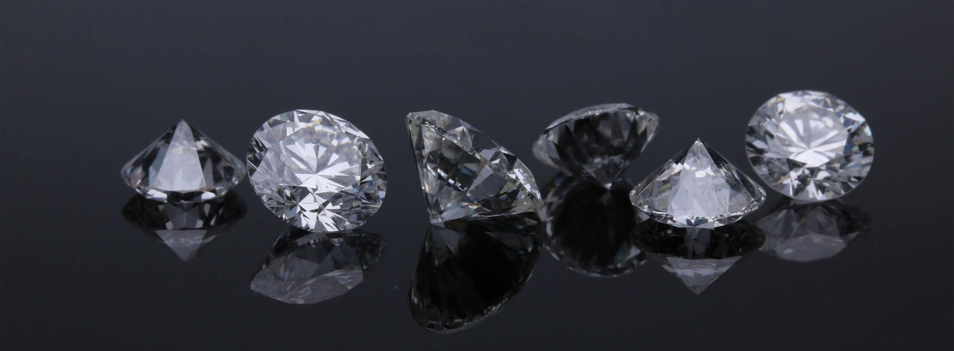 A group of diamonds sitting on top of each other on a black surface.
