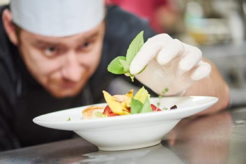 chef che completa un piatto