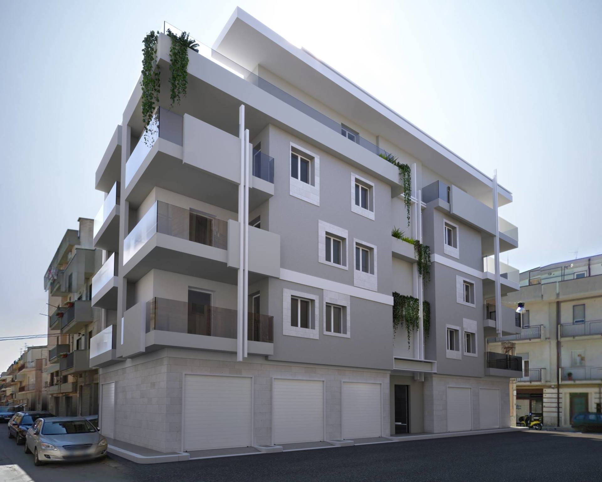 Un moderno edificio residenziale grigio di quattro piani con dettagli bianchi, balconi e portoni del garage al piano terra, affacciato su una strada.