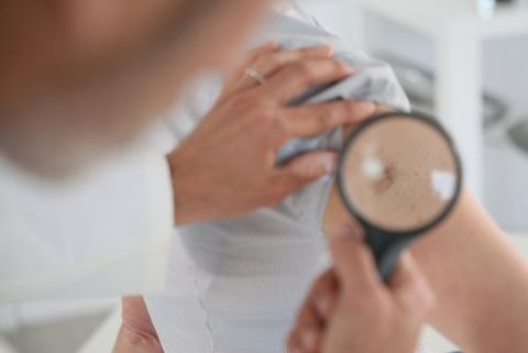 Dr. Pasquale Ena mentre controlla un paziente con lente d'ingrandimento