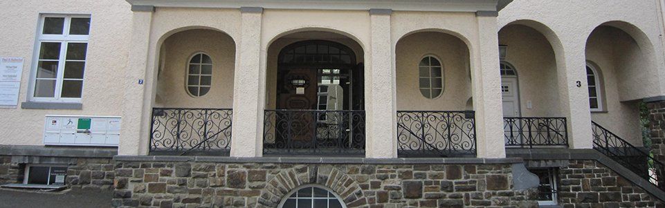 Die Vorderseite eines Gebäudes mit Bögen und Treppen