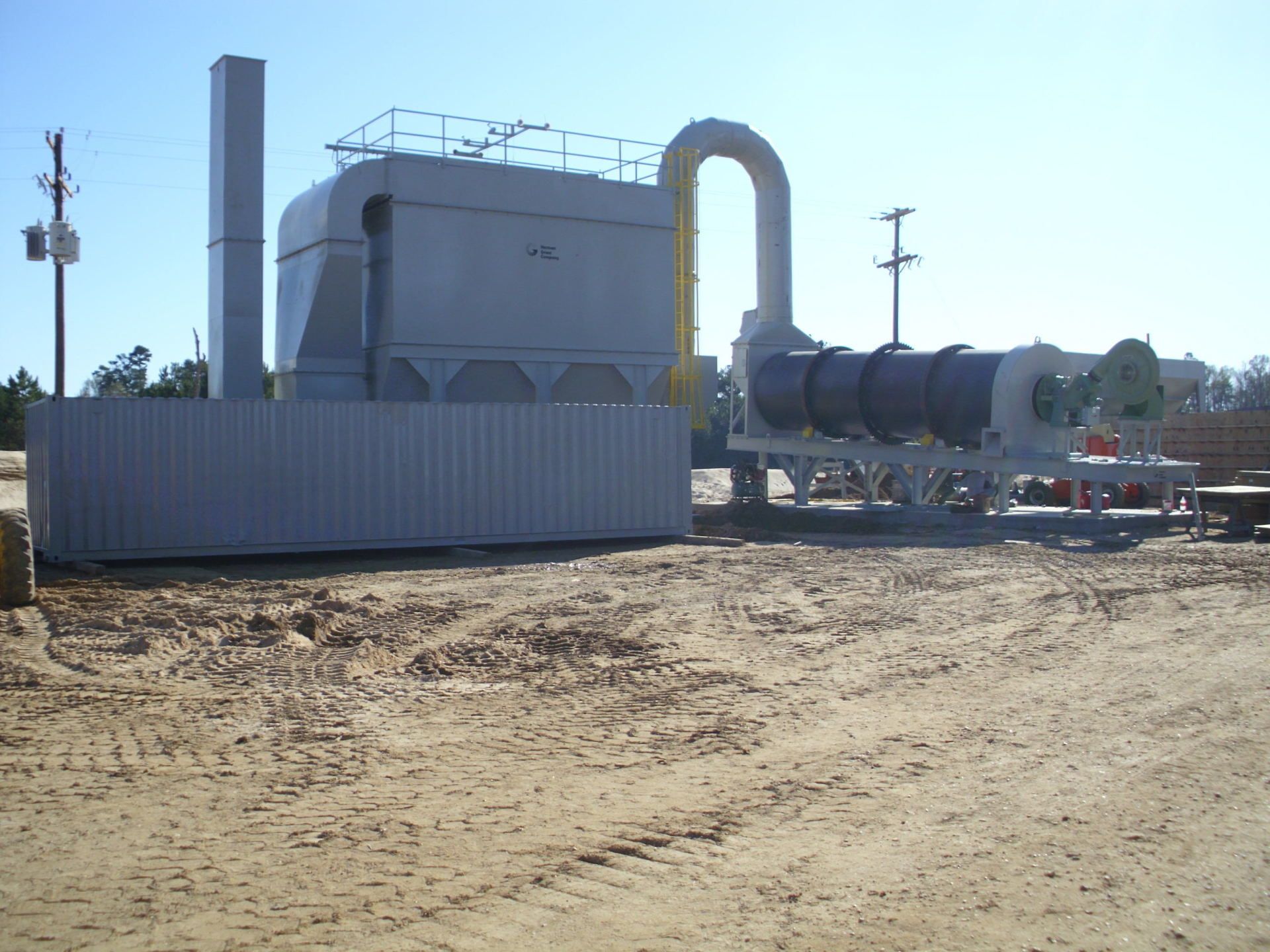 A large machine is sitting in the middle of a dirt field