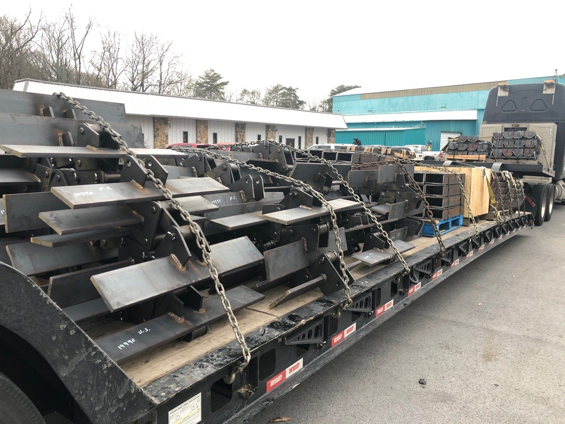 A semi truck is carrying a large piece of metal on a trailer.