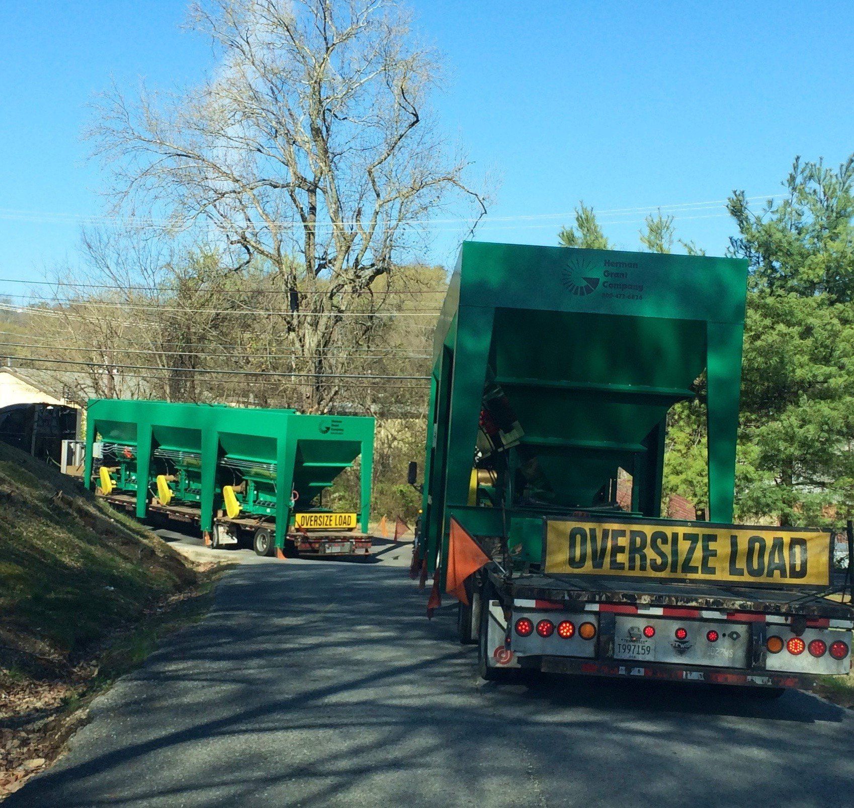 An oversize load truck is driving down a road