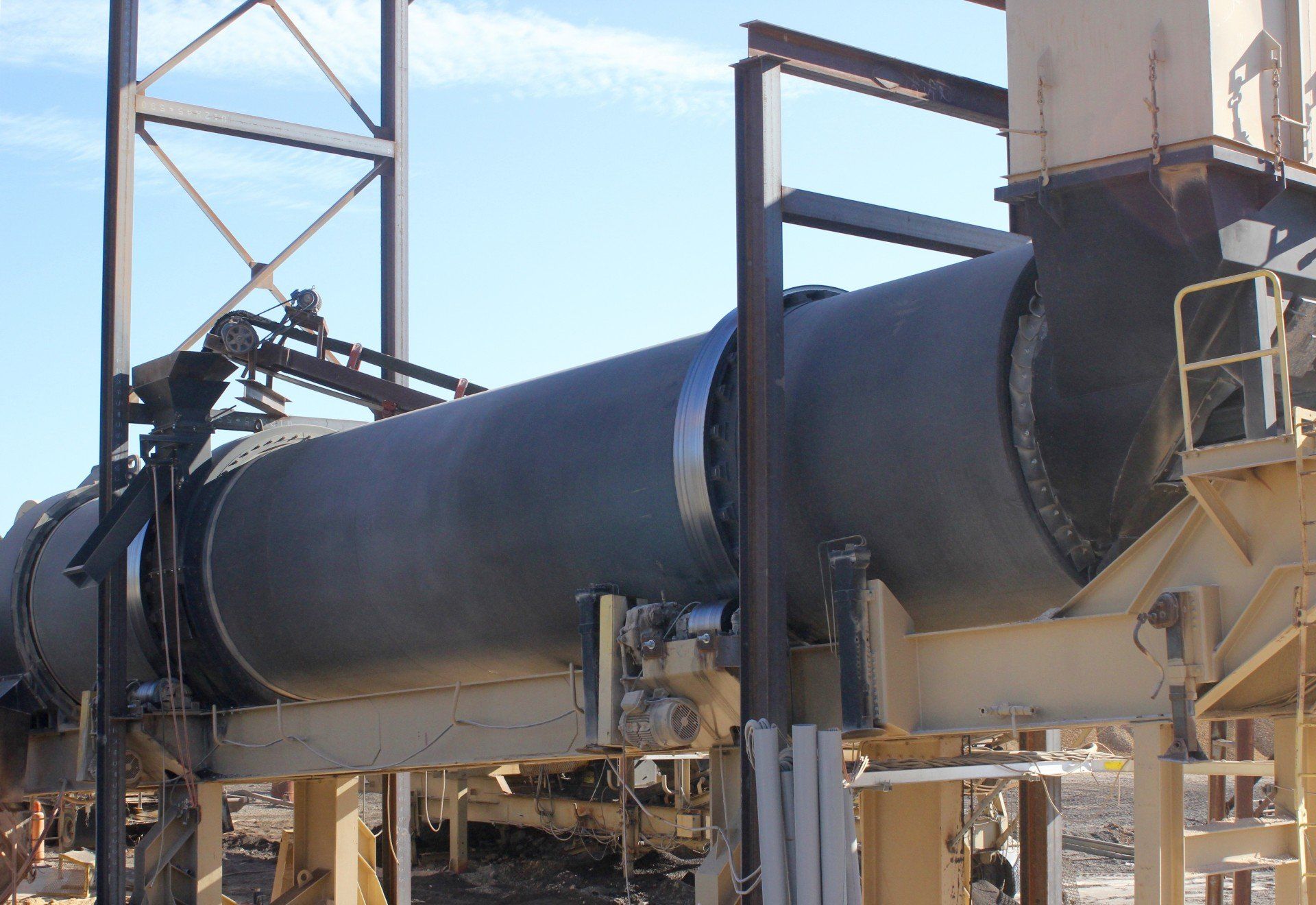 A large pipe in a factory with a blue sky in the background