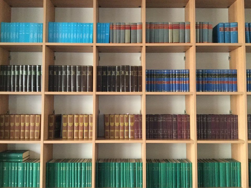 Scaffali pieni di file di libri di vari colori.