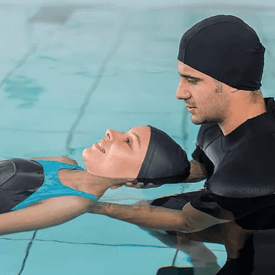 Therapist assisting a patient during aquatic physical therapy in a pool.
