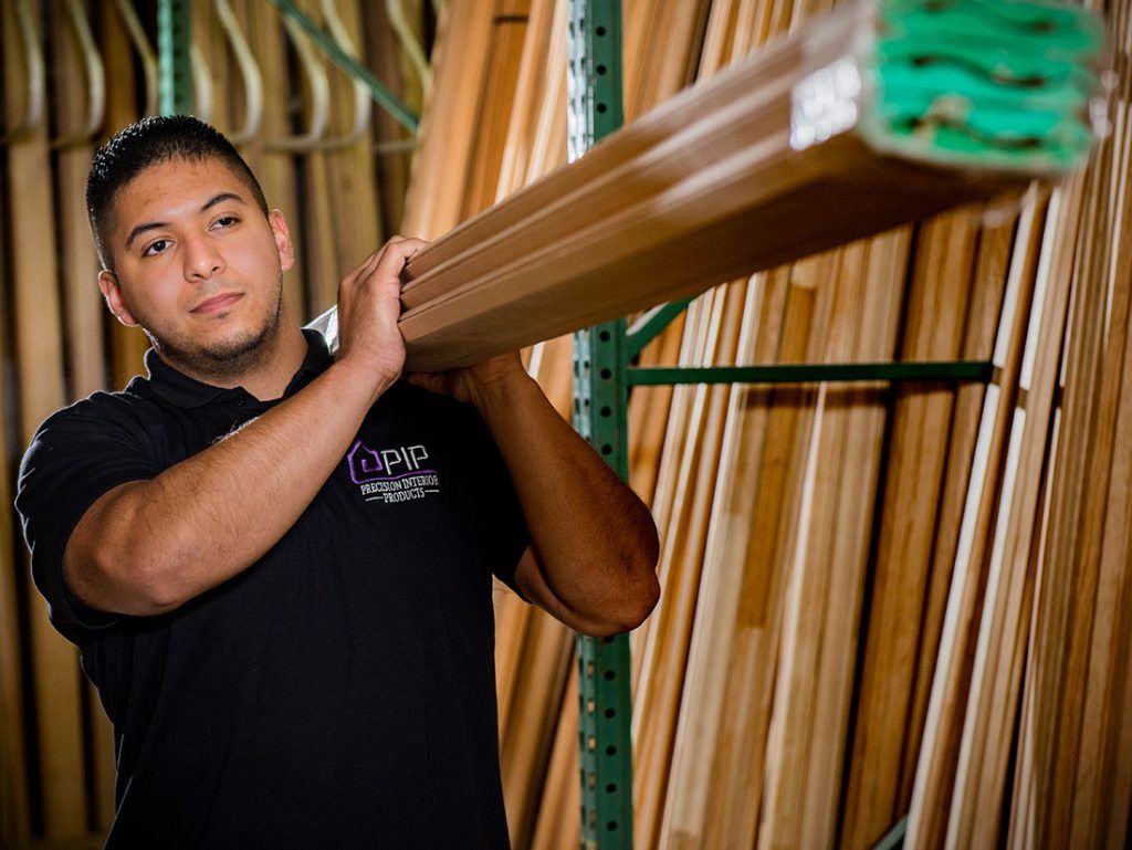 Worker transporting wood from shop