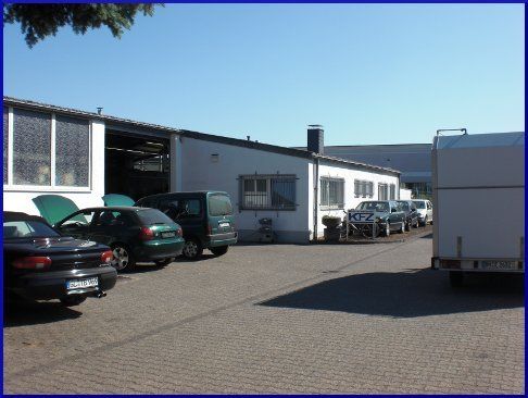 Eine Reihe von Autos sind vor einem Gebäude mit der Aufschrift kfz geparkt