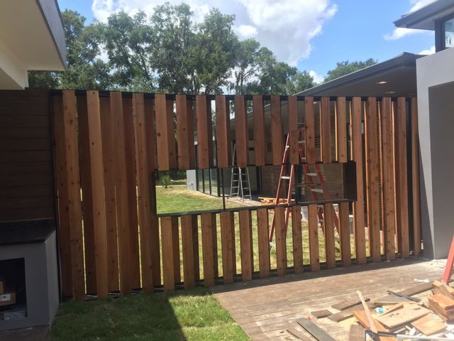 A wooden fence is being built in front of a house.
