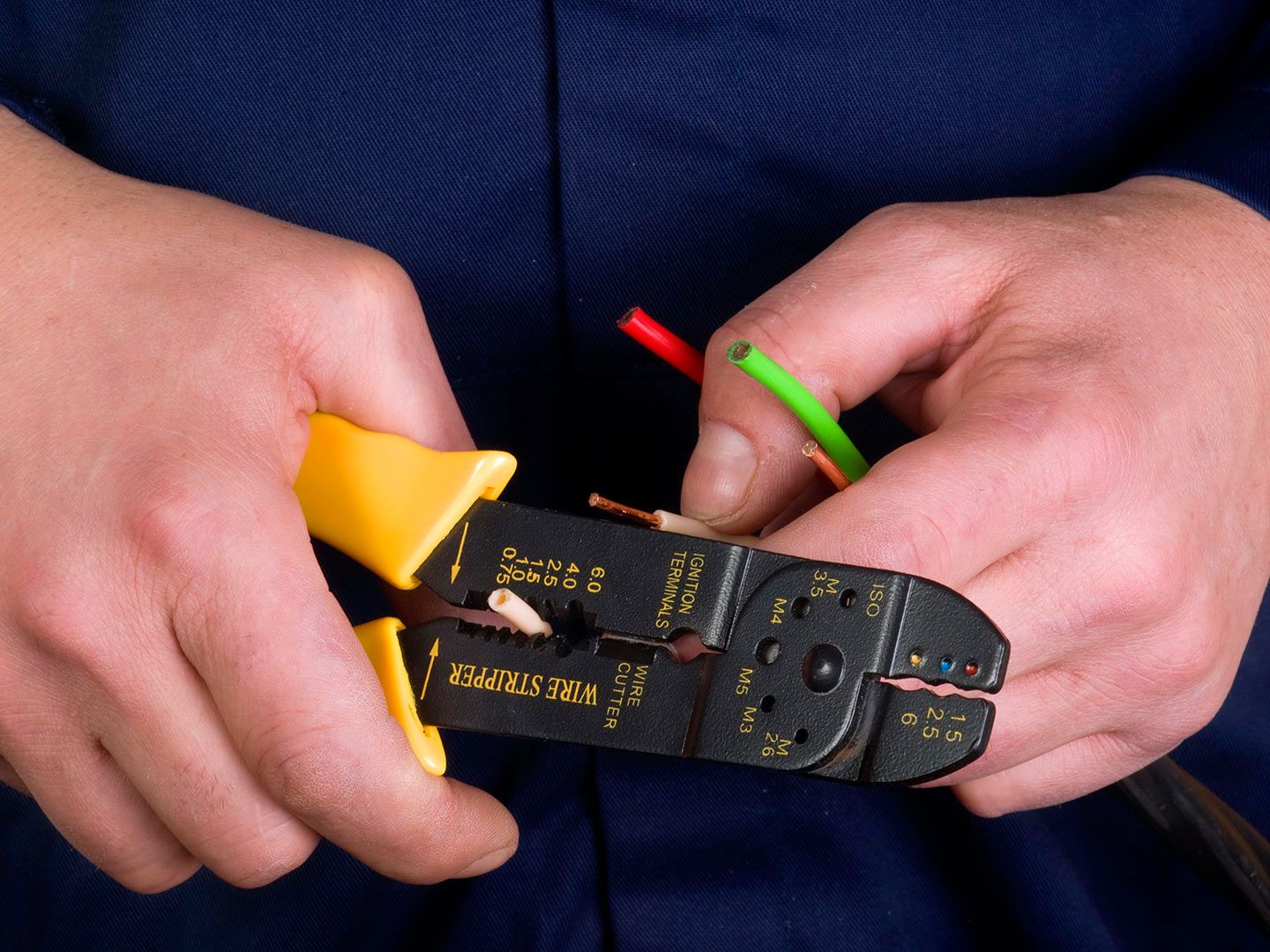 Primo piano di una pinza da elettricista mentre trancia dei cavetti elettrici